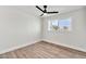 Minimalist bedroom with new vinyl floors, ceiling fan, and large window offering street view at 455 E Garfield St, Tempe, AZ 85288