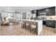 Modern open-concept kitchen features sleek black cabinets, quartz countertops and an island with bar seating at 455 E Garfield St, Tempe, AZ 85288
