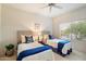 Bright bedroom featuring two twin beds, soft carpet, ceiling fan, and views through a window at 4744 E Casey Ln, Cave Creek, AZ 85331