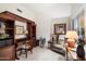 Traditional home office featuring built-in wooden shelving, a desk, and a cozy armchair at 4744 E Casey Ln, Cave Creek, AZ 85331