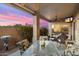 Outdoor patio area with glass top table and chairs, ceiling fan, and a lovely sunset sky at 4744 E Casey Ln, Cave Creek, AZ 85331
