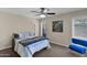 Inviting bedroom with a ceiling fan, two windows, and a chair, perfect for relaxation and comfort at 4828 E Capistrano Ave, Phoenix, AZ 85044