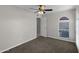 Bedroom featuring neutral walls, carpeted floor, ceiling fan and a arched window at 4828 E Capistrano Ave, Phoenix, AZ 85044