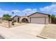 Tan single story home featuring a desert xeriscaped front yard and two car garage at 4828 E Capistrano Ave, Phoenix, AZ 85044