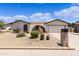 Tan single story home featuring a xeriscaped front yard, archway entry and two car garage at 4828 E Capistrano Ave, Phoenix, AZ 85044