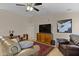 Spacious living room featuring tile floors, a ceiling fan, and comfortable leather furniture at 4828 E Capistrano Ave, Phoenix, AZ 85044