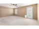 Empty carpeted bedroom with a ceiling fan, large window, and closet door at 494 W Midland Ln, Gilbert, AZ 85233