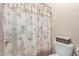 Bathroom featuring a palm-themed shower curtain and a toilet with a basket on top at 5335 E Shea Blvd # 2102, Scottsdale, AZ 85254