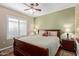 Spacious bedroom featuring a king-sized bed, ceiling fan, and window with plantation shutters at 5335 E Shea Blvd # 2102, Scottsdale, AZ 85254