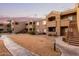 Apartment building exterior with landscaped lawn, stairs, and pathways at sunset at 5335 E Shea Blvd # 2102, Scottsdale, AZ 85254