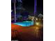 Resort-style pool surrounded by palm trees and lounge chairs, illuminated at night at 5335 E Shea Blvd # 2102, Scottsdale, AZ 85254