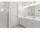 Bright bathroom featuring double vanity with white cabinetry, modern fixtures and glass-enclosed shower at 5358 W Las Palmaritas Dr, Glendale, AZ 85302