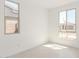 Bright, empty bedroom with two large windows, light tile floors, and electrical outlets at 5358 W Las Palmaritas Dr, Glendale, AZ 85302