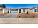 Beautiful single-story home featuring a gray garage door and a stone brick exterior at 5358 W Las Palmaritas Dr, Glendale, AZ 85302