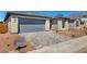 Charming single-story home featuring a gray garage door and a stone brick exterior at 5358 W Las Palmaritas Dr, Glendale, AZ 85302