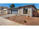 Street view showcasing desert landscaping, brick driveway, and a modern grey two-car garage at 5358 W Las Palmaritas Dr, Glendale, AZ 85302