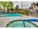 Community pool with nearby hot tub and lounge chairs and landscaped grounds surrounding the area at 5995 N 78Th St # 1063, Scottsdale, AZ 85250