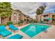Relaxing community pool surrounded by lounge chairs, lush landscaping, and multi-story apartments at 5995 N 78Th St # 1063, Scottsdale, AZ 85250