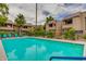 Community pool surrounded by lush landscaping and multi-story apartments. Shallow water sign visible at 5995 N 78Th St # 1063, Scottsdale, AZ 85250