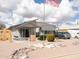 Single-story home with an American flag, desert landscaping, and covered parking at 614 S 92Nd Pl, Mesa, AZ 85208