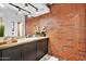Chic bathroom with a vintage vanity, exposed brick, and modern fixtures at 7301 E 3Rd Ave # 121, Scottsdale, AZ 85251