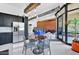 Modern kitchen and dining area with black cabinetry, stainless steel appliances, and exposed brick accent wall at 7301 E 3Rd Ave # 121, Scottsdale, AZ 85251