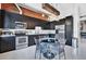 Stylish kitchen with sleek black cabinets, stainless steel appliances, and an exposed brick wall at 7301 E 3Rd Ave # 121, Scottsdale, AZ 85251