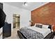 Inviting main bedroom with brick accent wall, closet and walk in shower at 7301 E 3Rd Ave # 121, Scottsdale, AZ 85251