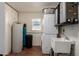 Bright laundry room boasts stacked washer/dryer, utility sink, and storage at 904 W Juanita Ave, Mesa, AZ 85210