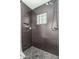 Modern shower featuring dark subway tile, pebble flooring, glass block window, and convenient built-in niche at 904 W Juanita Ave, Mesa, AZ 85210