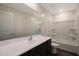 Well-lit bathroom featuring modern vanity, full mirror, and shower-tub combination with white tiling at 1057 W West Virginia Ave, Florence, AZ 85132