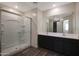 Contemporary bathroom with a glass-enclosed shower, double vanity, and wood-look flooring at 1057 W West Virginia Ave, Florence, AZ 85132