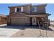 Two-story home featuring a two-car garage, a covered porch, and low-maintenance gravel landscaping at 1057 W West Virginia Ave, Florence, AZ 85132