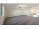 Bright living room with neutral carpet, ceiling fan, and ample natural light streaming through large windows at 1057 W West Virginia Ave, Florence, AZ 85132