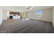 Spacious living room showcasing an open layout with kitchen, wood-look flooring and cozy carpet at 1057 W West Virginia Ave, Florence, AZ 85132