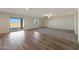 Open-concept living space with wood-look flooring, carpeted area, and sliding glass doors to the backyard at 1057 W West Virginia Ave, Florence, AZ 85132