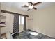 A simple bedroom with wood accent, patterned curtains and rug, and a ceiling fan at 10916 E Cholla Rd, Mesa, AZ 85207