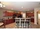 A spacious kitchen features wood cabinets, an island with bar stool seating, and modern appliances at 10916 E Cholla Rd, Mesa, AZ 85207