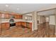 Spacious kitchen features wood cabinetry, stainless steel appliances, laminate floors, and an open layout into the living area at 10938 W Pierson St, Phoenix, AZ 85037