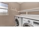 Practical laundry area with modern machines, ample countertop space, and bright lighting at 10938 W Pierson St, Phoenix, AZ 85037