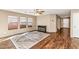 Bright living room featuring laminate flooring, a ceiling fan, neutral walls, and abundant natural light from large windows at 10938 W Pierson St, Phoenix, AZ 85037