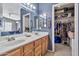 Bathroom featuring double sinks, large mirror, lighting, and walk-in closet at 1150 E Liberty Shores Dr, Gilbert, AZ 85234