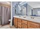 Bathroom featuring double sinks, large mirror, lighting, and walk-in shower at 1150 E Liberty Shores Dr, Gilbert, AZ 85234