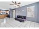 Living room with tile flooring, a ceiling fan, and access to the kitchen at 1150 E Liberty Shores Dr, Gilbert, AZ 85234
