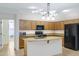 Bright kitchen showcasing wooden cabinets, sleek black appliances, and a center island that enhances workflow and entertaining at 1358 E Angie St, Casa Grande, AZ 85122