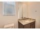 A bathroom features a granite-topped vanity, a large mirror, and a window with blinds at 15032 W Gray Fox Trl, Surprise, AZ 85387