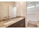 Bathroom with dual vanity featuring granite counters and tile floors at 15032 W Gray Fox Trl, Surprise, AZ 85387