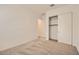 This carpeted bedroom has white trim, white walls, a closet, and a door leading to another room at 15032 W Gray Fox Trl, Surprise, AZ 85387