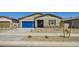 Charming single-story home featuring a blue garage door and low-maintenance desert landscaping in the front yard at 15032 W Gray Fox Trl, Surprise, AZ 85387