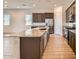 Kitchen features an island, granite countertops, stainless steel appliances, and wood-look tile floors at 15032 W Gray Fox Trl, Surprise, AZ 85387